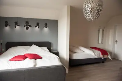a bedroom with a bed with red pillows on it at Villa Lumina in Membach