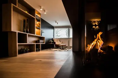 a living room with a fireplace and a chair at Wellness Hasselt B&B in Hasselt
