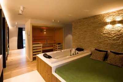 a bathroom with a large bath tub with a green rug at Wellness Hasselt B&B in Hasselt