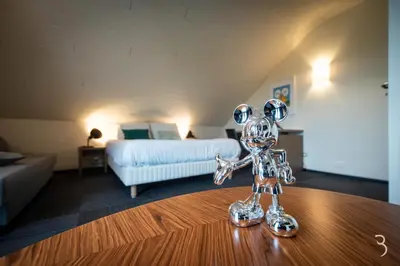 a small silver sculpture on a table in a room at Smart Bnb - Hotel Battice in Battice
