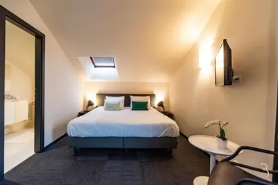 a bedroom with a bed and a table and a mirror at Smart Bnb - Hotel Battice in Battice