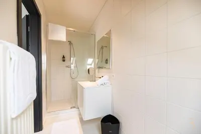 a white bathroom with a shower and a toilet at Smart Bnb - Hotel Battice in Battice
