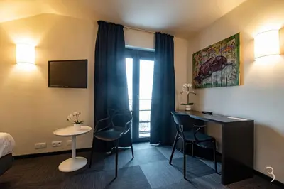 a hotel room with a bed and a desk in a room at Smart Bnb - Hotel Battice in Battice