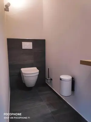 a bathroom with a toilet and a trash can at DayNight Sauveniere in Liège