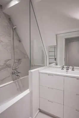 a white bathroom with a sink and a shower at Faubourg Saint Martin in Liège
