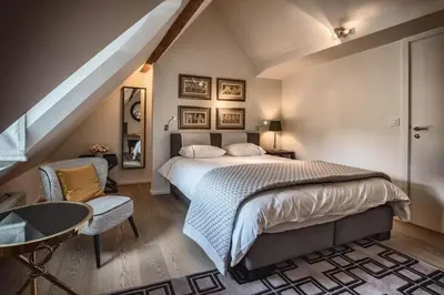 a bedroom with a bed and a table and chairs at Faubourg Saint Martin in Liège