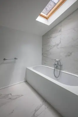 a white bathroom with a bath tub and a window at Faubourg Saint Martin in Liège