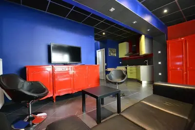 a living room with red furniture and a blue wall at Maisonnette in Liège