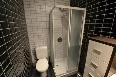 a bathroom with a toilet and a glass shower at Maisonnette in Liège