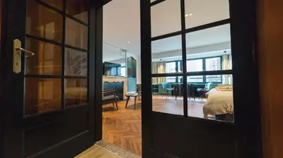 an open door to a room with a bed and a living room at B&B The Street Lodge in Liège