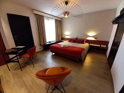 a hotel room with a bed and a table and chairs at B&B The Street Lodge in Liège