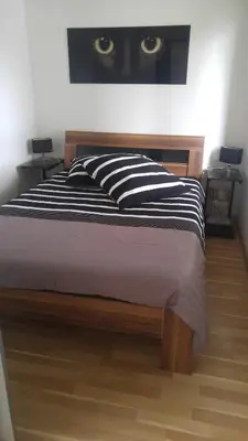 a bed with a black and white pillow with a cat on the wall at Ferienhaus Congolo in Lontzen