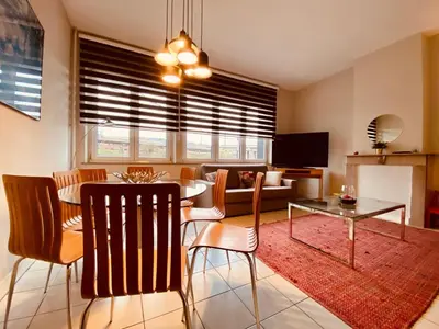 a living room with a table and a dining room at Fenêtre sur le Standard de Liège in Ougrée