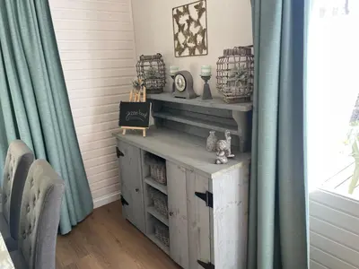 a room with blue curtains and a table with drawers at Chalet Sint-Hubertus in Zutendaal