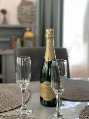 a bottle of champagne and two wine glasses on a table at Chalet Sint-Hubertus in Zutendaal