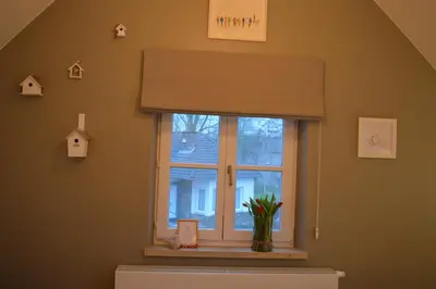 a window in a room with a vase with a plant at Maison Margriet in Tongeren