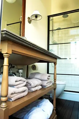 a pile of towels on a shelf in a bathroom at B&B Villa des Roses in Hasselt