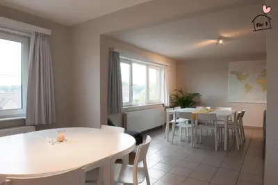 a dining room with white tables and white chairs at De Vlier - Vakantiewoningen in Maasmechelen