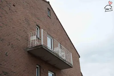 a brick building with a balcony on the side of it at De Vlier - Vakantiewoningen in Maasmechelen