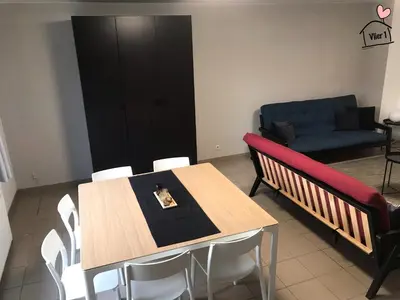a dining room with a table and a couch at De Vlier - Vakantiewoningen in Maasmechelen