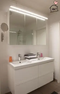 a bathroom with a white sink and a mirror at De Vlier - Vakantiewoningen in Maasmechelen