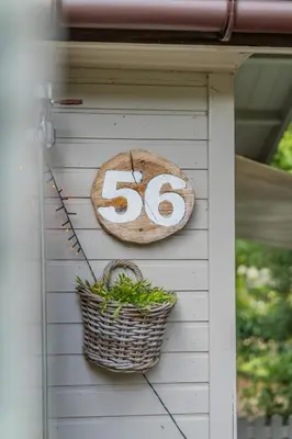 a sign on the side of a house with a basket at Chalet Relax in Zutendaal