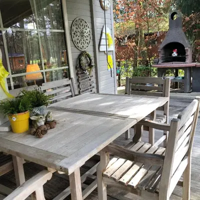 a wooden picnic table on the porch of a house at Chalet Relax in Zutendaal