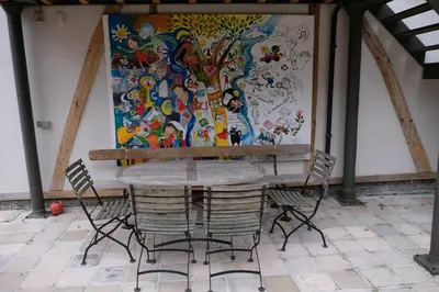 a table and chairs in front of a painting at Abeljano in Hasselt