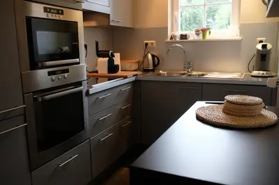 a kitchen with a sink and a stove top oven at Abeljano in Hasselt