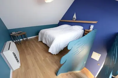 a bedroom with a white bed and a blue wall at Les Coteaux du Vinave in Herve