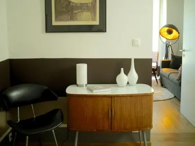 a living room with a table and a chair at Gîte Au26 côté jardin-côté cour in Liège