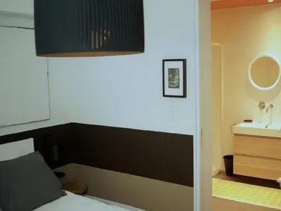 a bedroom with a bed and a sink at Gîte Au26 côté jardin-côté cour in Liège