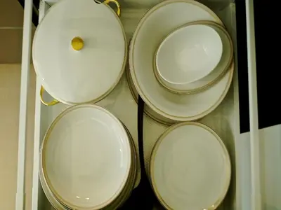 a group of white plates on a shelf at Gîte Au26 côté jardin-côté cour in Liège