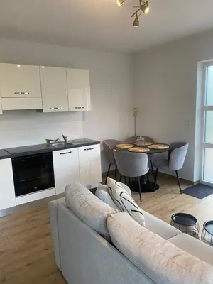 a living room with a couch and a kitchen and a table at InContri in Liège