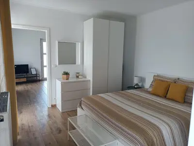 a white bedroom with a bed and a television at InContri in Liège