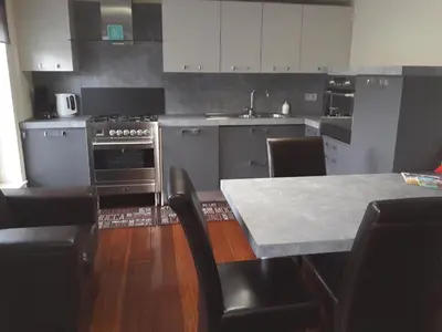 a kitchen with a stove and a table with chairs at Cosy Corner in Lommel