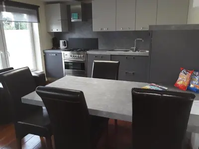 a kitchen with a table and chairs and a sink at Cosy Corner in Lommel
