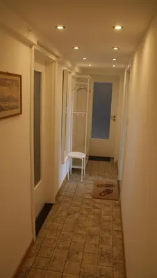 a hallway with a white chair in a room at Übernachten im ehemaligen Zollgebäude in Hauset