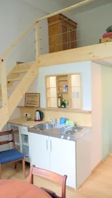 a kitchen with a loft with a sink and a staircase at Übernachten im ehemaligen Zollgebäude in Hauset