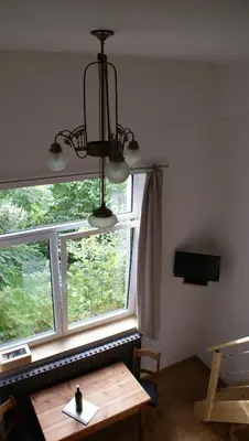 a chandelier hanging over a table in front of a window at Übernachten im ehemaligen Zollgebäude in Hauset