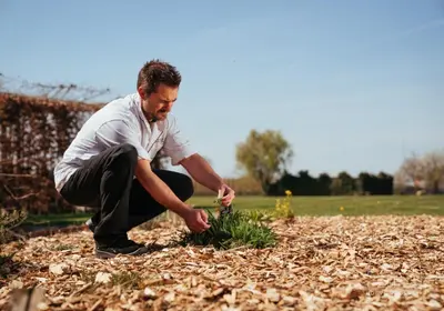 a man planting a plant in a garden at Hoeve Roosbeek in Zepperen