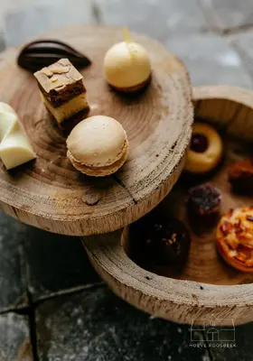 a wooden plate with different types of pastries on it at Hoeve Roosbeek in Zepperen