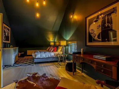 a attic room with a bed and a table at Luxurious holiday home in Heers with terrace in Mettekoven