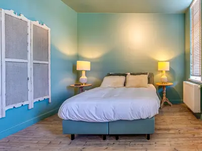 a bedroom with a bed with blue walls and two lamps at Luxurious holiday home in Heers with terrace in Mettekoven