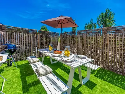 a white table with an umbrella and two chairs at Luxurious holiday home in Heers with terrace in Mettekoven