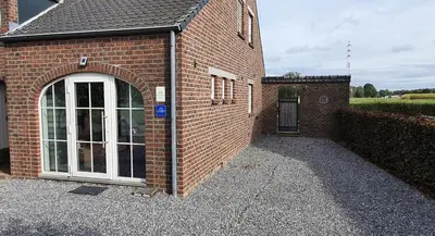 a brick building with a window and a door at 't Hagerhuys in Maaseik
