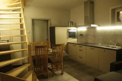 a kitchen with a table and chairs and a kitchen with a ladder at 't Hagerhuys in Maaseik