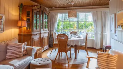 a living room with a table and chairs and a window at Chalet Luxe in Zutendaal