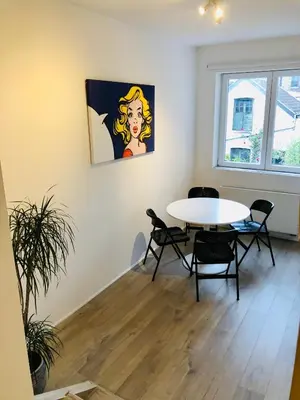 a dining room with a table and chairs in a room at Lyves in Liège