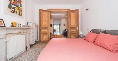a bedroom with a red bed and a fireplace at Lyves in Liège